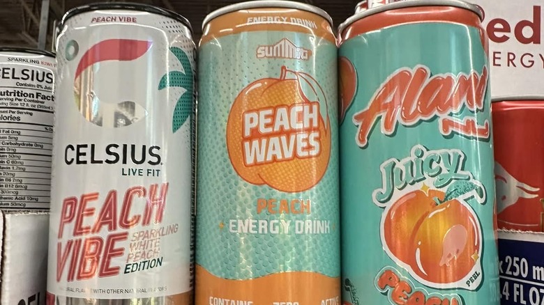 Celsius, Summit, and Alani peach-flavored energy drink lined up in a row