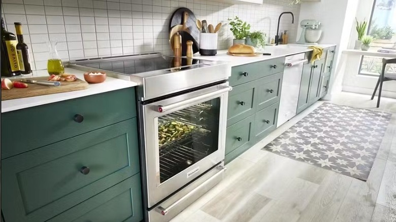 KitchenAid 30-inch 4-element induction slide-in convection range tucked into a kitchen