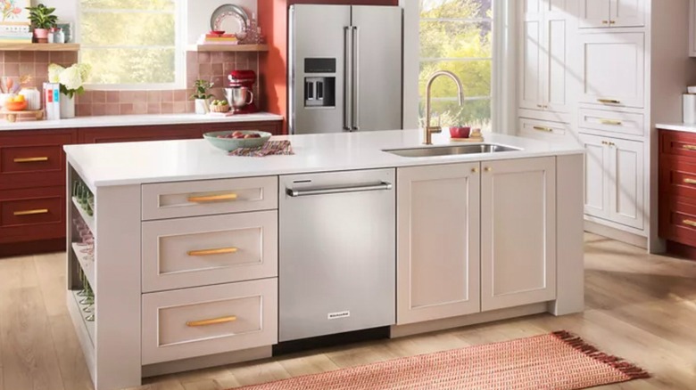KitchenAid hidden control dishwasher in a kitchen island within a red and white kitchen
