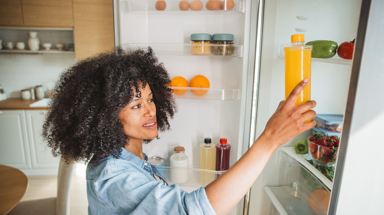 Woman putting items in fridge