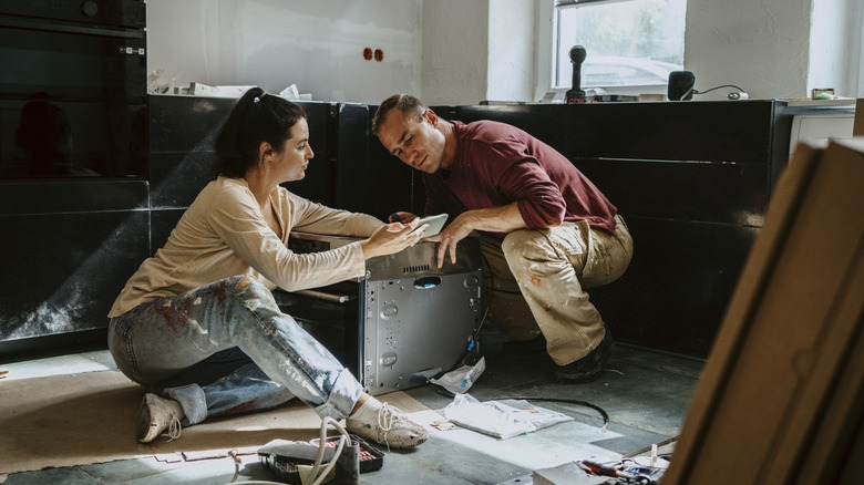 Couple installing a dishwasher
