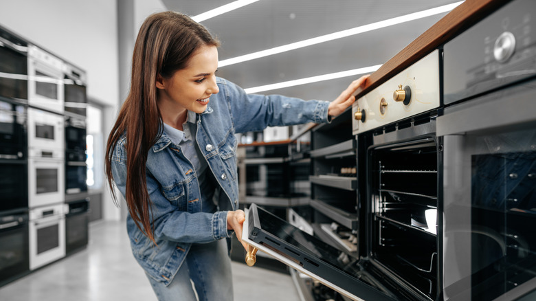 Young woman shopping for ovens