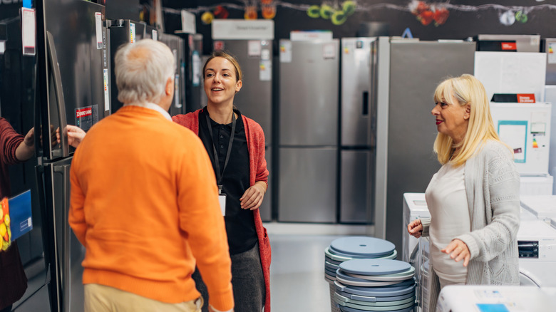Older couple shopping for refrigerators
