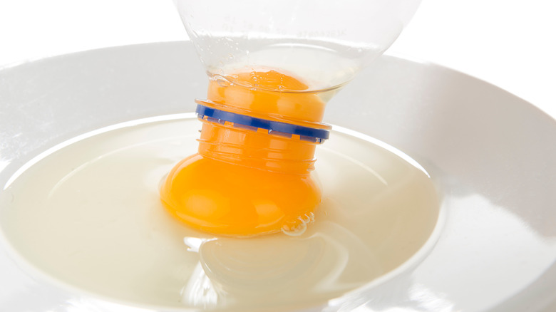 An egg being separated using a plastic bottle