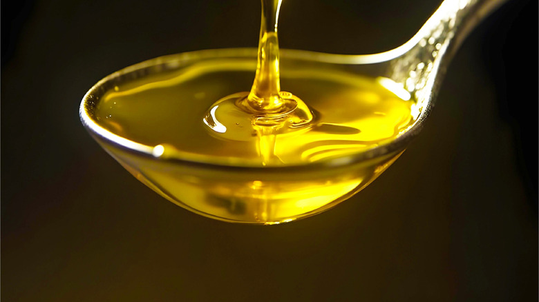 olive oil pouring into spoon