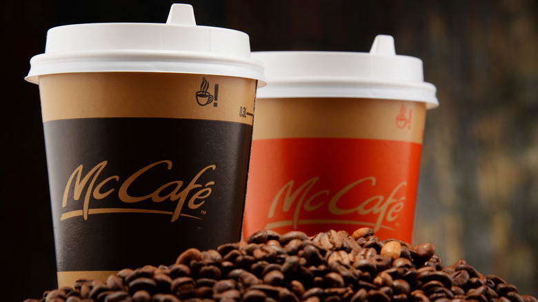 Two McCafe coffee drinks with a pile of coffee beans in front of them.