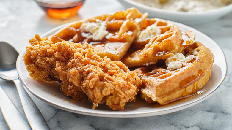 Chicken and waffles dish served on a white plate