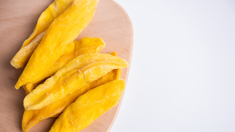 Dried mango slices on a wooden board