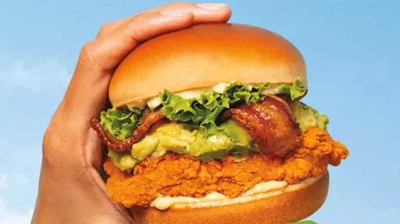 A person holding an Avocado Bacon Chicken Sandwich from Jollibee