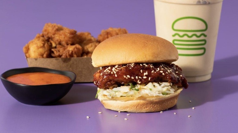 A K-Shack Fried Chicken Sandwich with sauce, chicken tenders, and a drink at Shake Shack