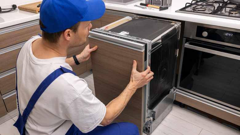 Person repairing a dishwasher