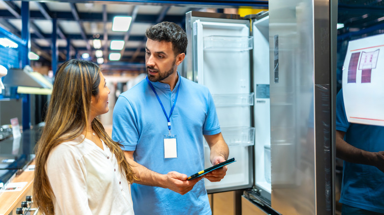 Person talking to salesperson at appliance store