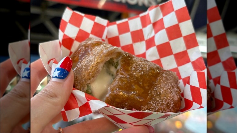 Churro cheesecake jalapeño popper in a small tray with checkered tissue paper