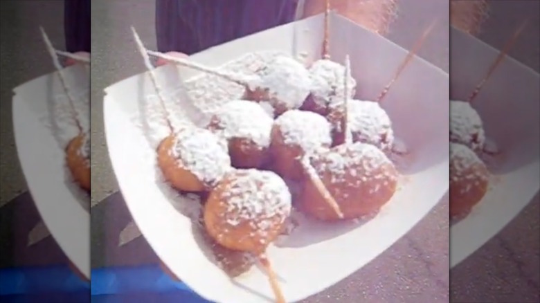 A tray of deep-fried Pepsi dough balls with powdered sugar on top