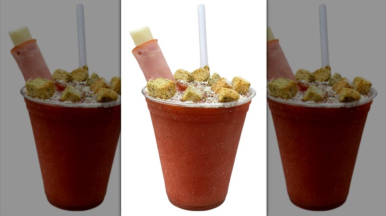 cup of blended pineapple and pizza sauce with cheese stick, croutons, and herbs on top
