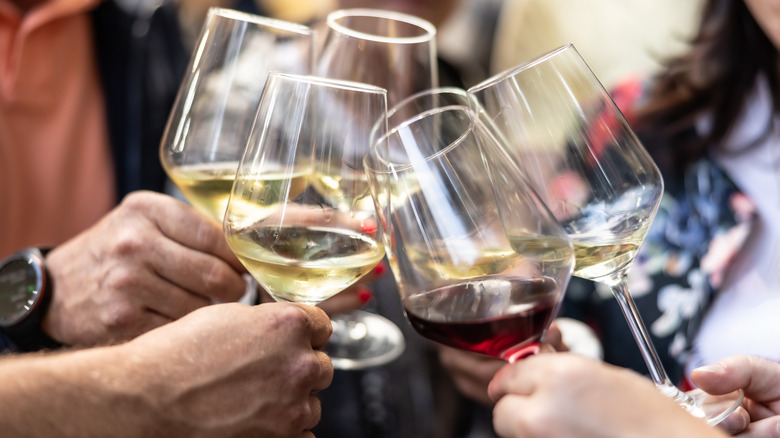 Hands clinking wine glasses