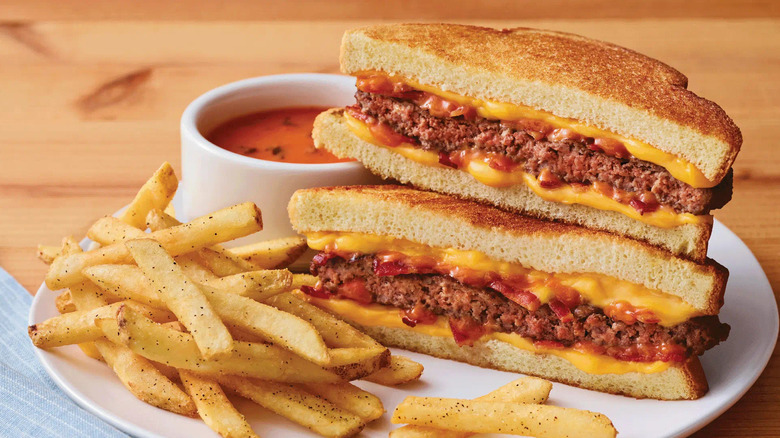 Applebee's grilled cheese cheeseburger, ketchup, and fries on a white plate