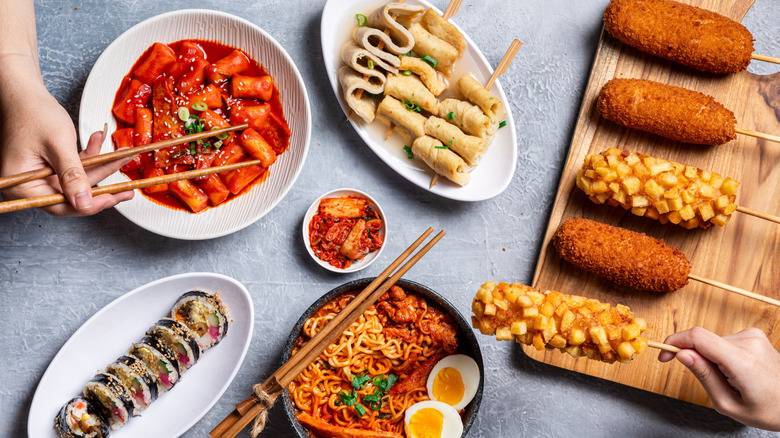 Korean hot dogs on cutting board along with other Korean dishes