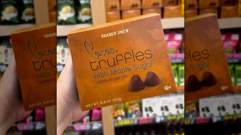 Hand holding a box of Trader Joe's Cocoa Truffles with Maple Sugar