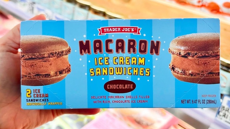 Hand holding a box of Trader Joe's Macaron Ice Cream Sandwiches