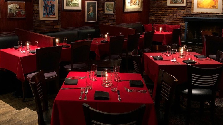 Fve tables with red tablecloths in Dear John's dining room