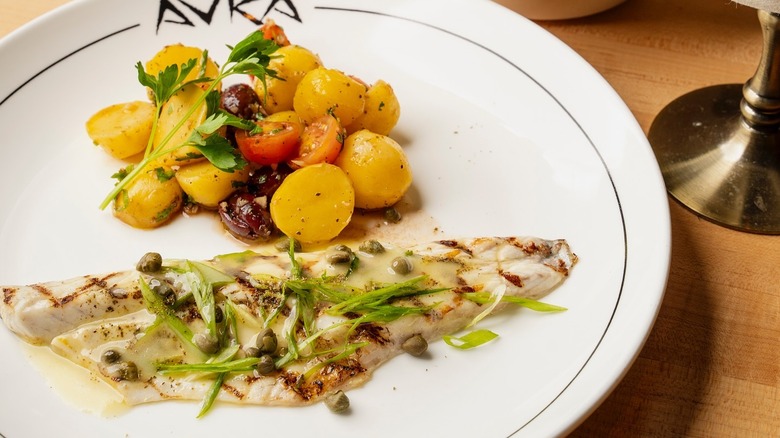 A plate of grilled fish and a tomato salad at Avra