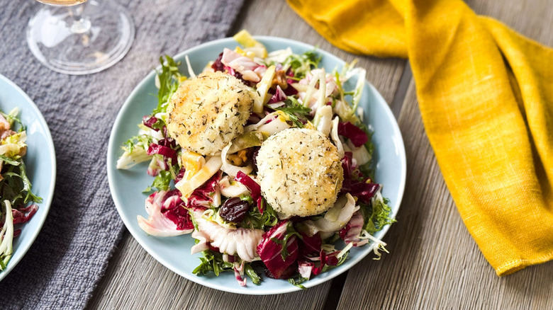 A blue plate of breaded and baked goat cheese salad