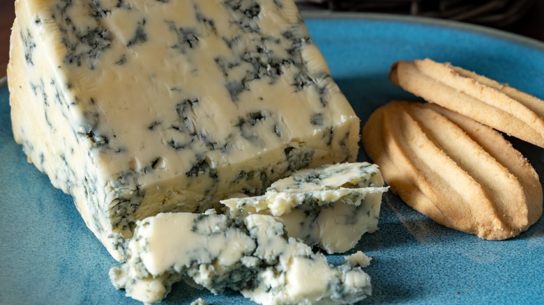 Crumbled blue cheese on a plate with crackers