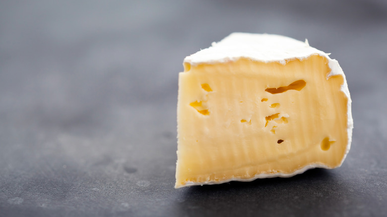 Brie cheese on a charcoal surface