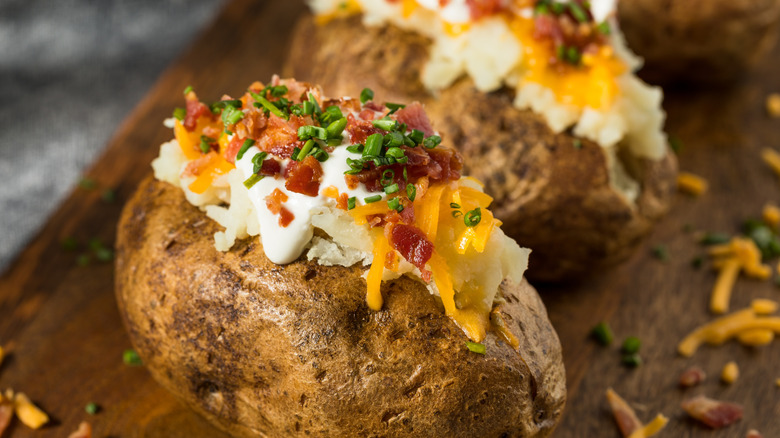 Loaded baked potatoes with shredded cheddar