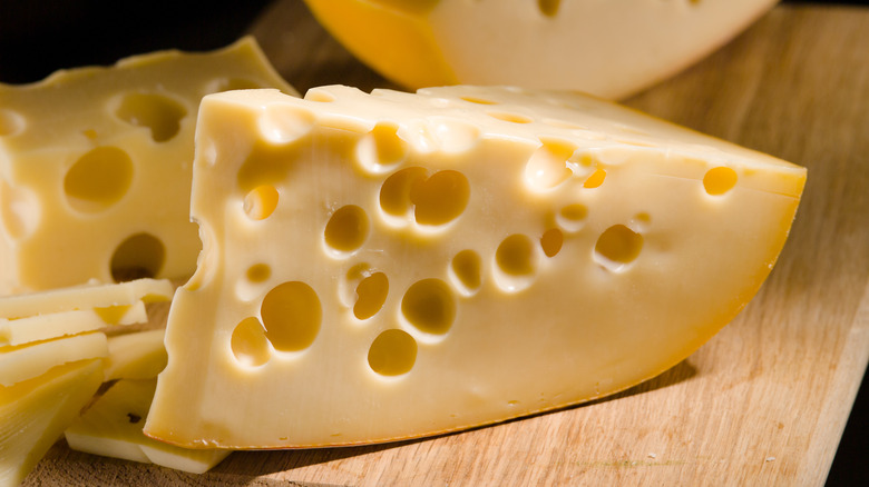 Swiss cheese on wooden cutting board