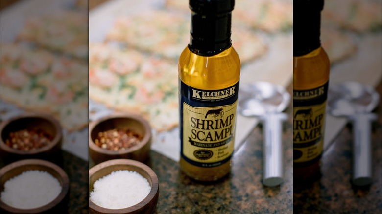 A bottle of Kelchner shrimp scampi next to salt and pepper on a counter