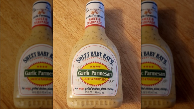 A bottle of Sweet Baby Ray's garlic parmesan marinade on a wooden table