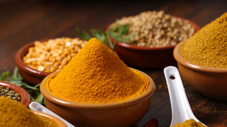 Spices and curry powder in brown bowls