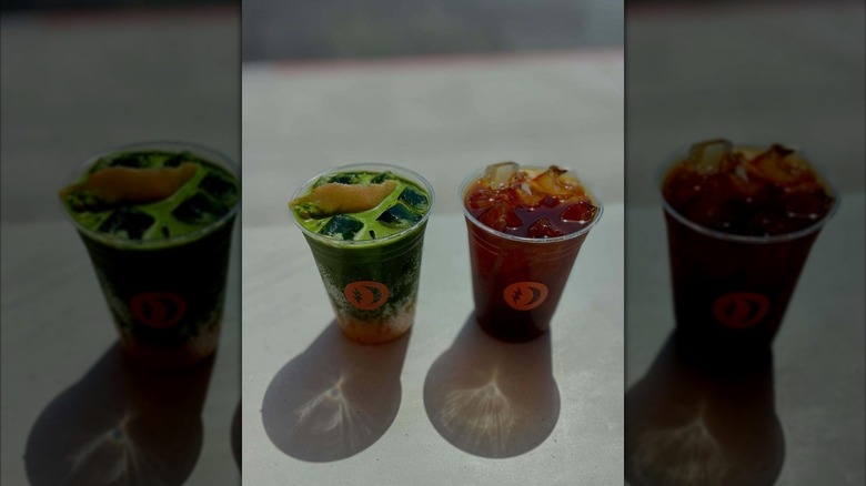 An iced matcha and iced coffee in takeout cups