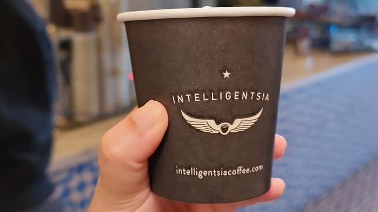 Someone holding a takeout coffee from Intelligentsia Coffee, LA