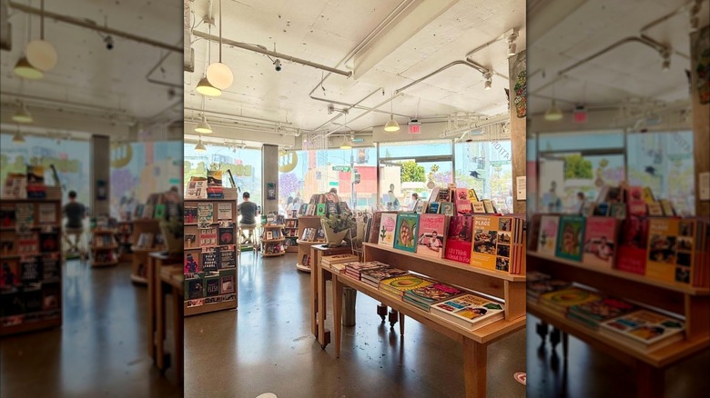 Tables and shelves stacked with books and large windows