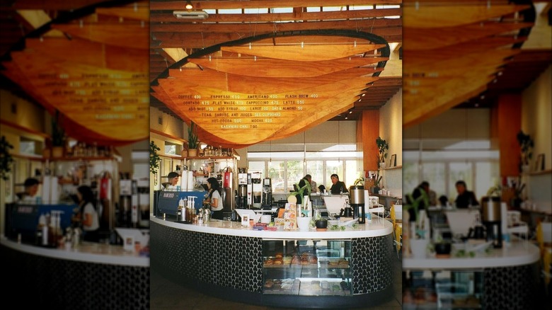 The large wooden menu board ceiling art at Dinosaur coffee