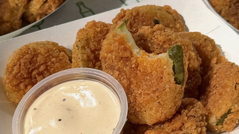 Fried pickles in a basket with sauce