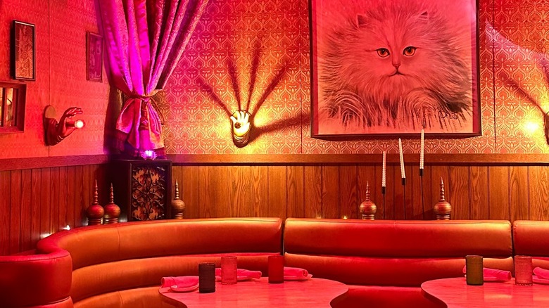 The interior of The Turk's Inn with moody lighting, leather couches, and a painting on the wall.