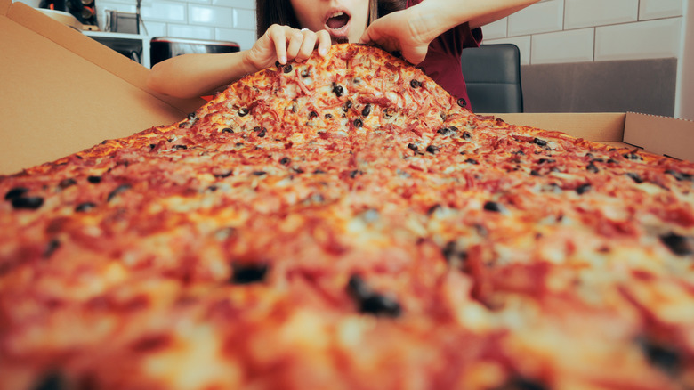 woman eating a giant pizza