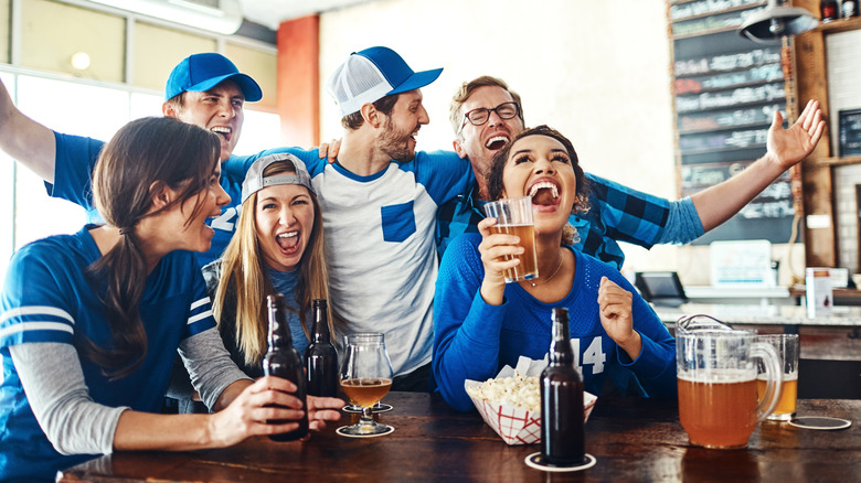 people cheering for a team at a restaurant