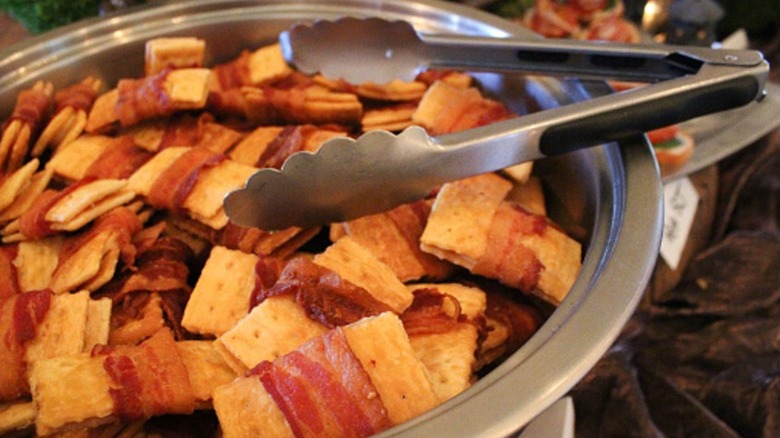 Crispy bacon-wrapped crackers in a serving dish.