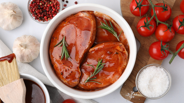 Cuts of beef marinating in a white ceramic bowl.