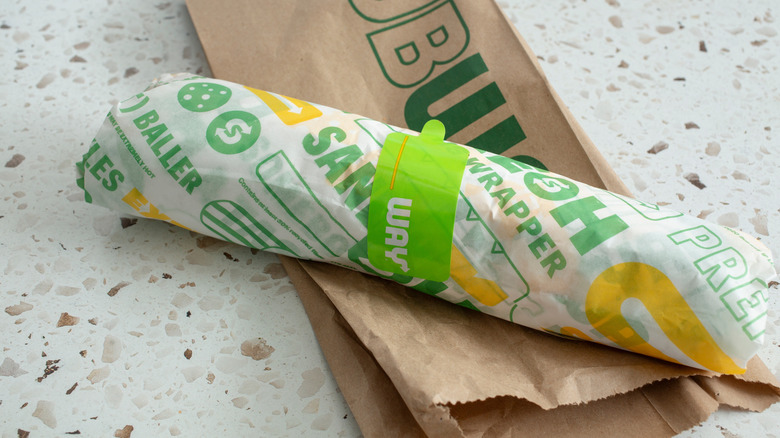 Wrapped Subway sandwich on a paper bag