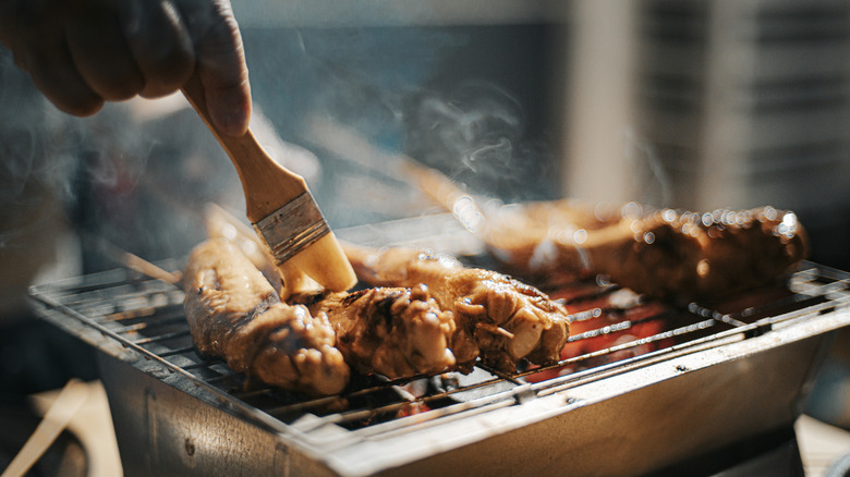 brushing on barbecue sauce for chicken