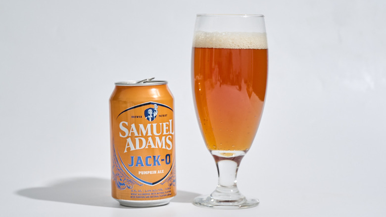 A can of Samuel Adams Jack-O Pumpkin Ale next to a glass of beer.