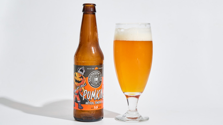 A bottle of Southern Tier Brewing Pumking beer next to a glass of beer.