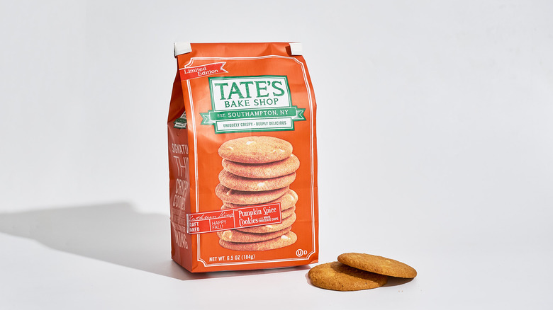 A bag of Tate's Bake Shop Pumpkin Spice Cookies with White Chocolate Chips next to cookies on a table.