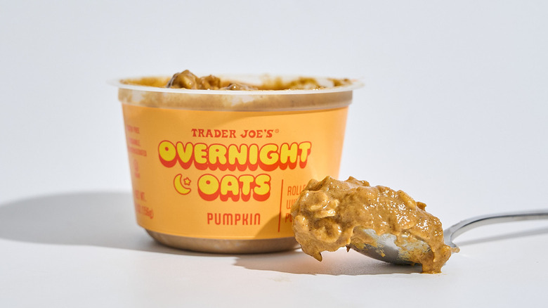 Container of Trader Joe's Pumpkin Overnight Oats next to a spoon filled with oats.